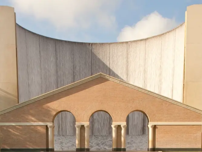 A curved water feature with a brick building in front of it